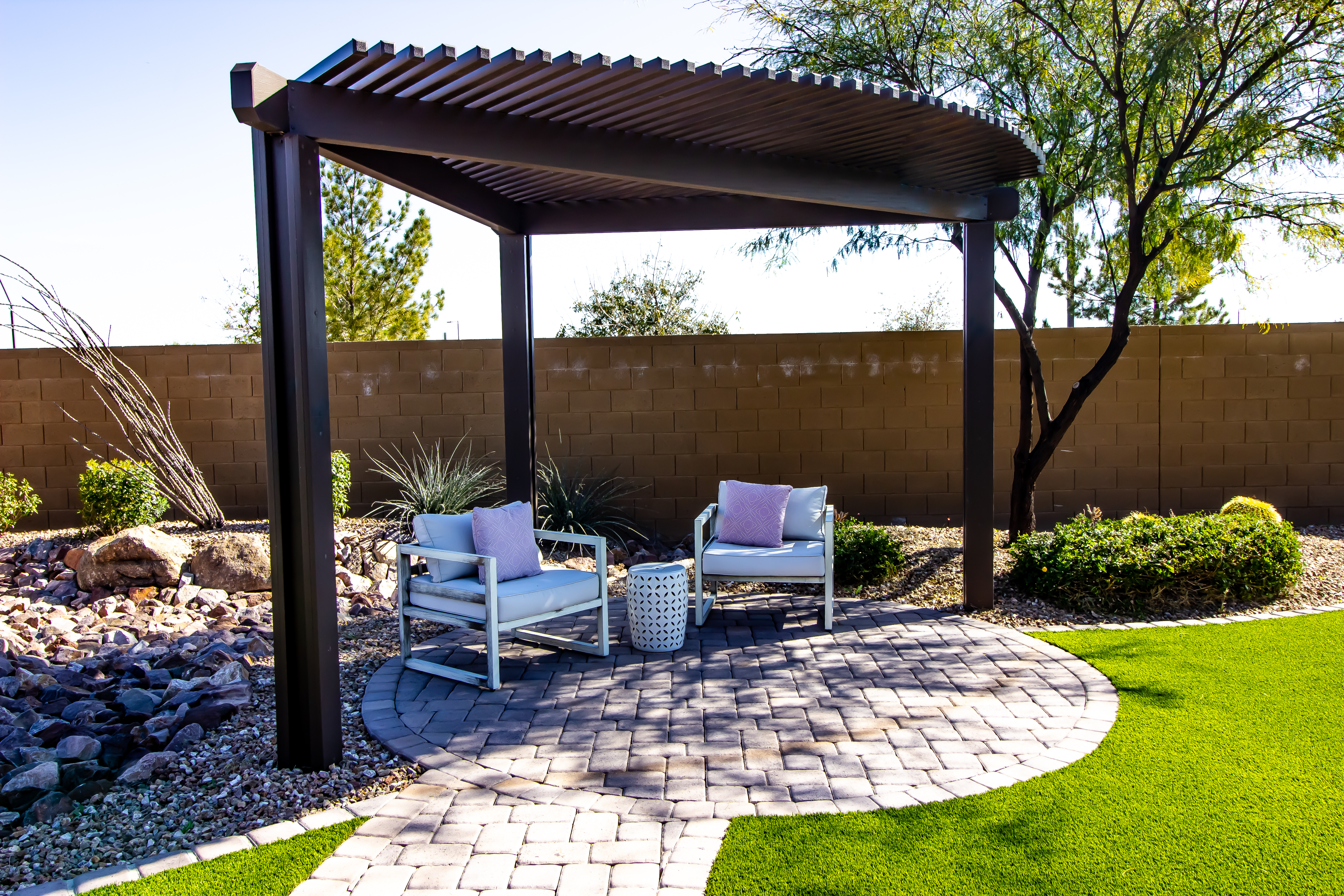 small steel
        triangle pergola over sitting area in small yard